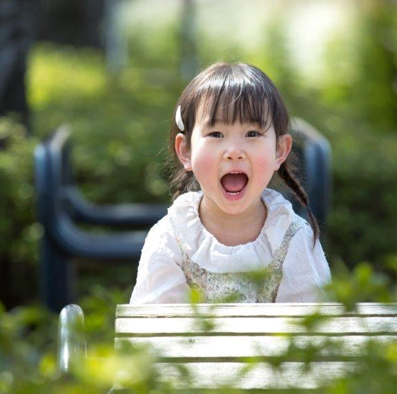 睡眠屋お昼寝布団のイメージ画像。小さな女の子が元気笑顔を見せている。