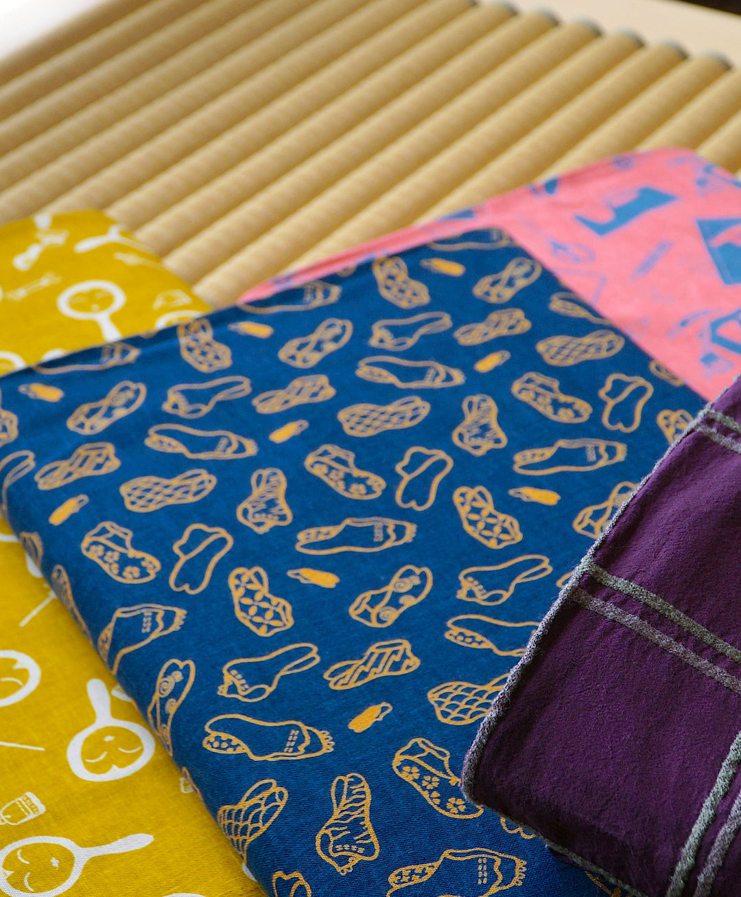 睡眠屋のお昼寝布団で使用する生地が山積みされている画像